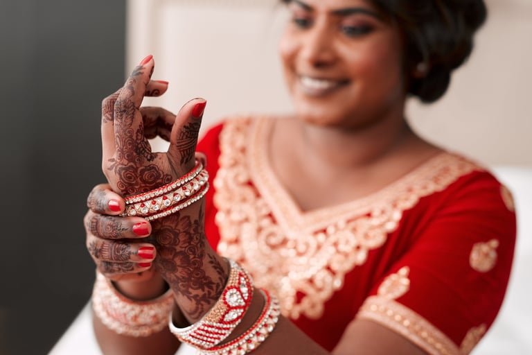 Zanzibar destination wedding film Tanzania — Beautiful Indian bride putting on gold bracelets during wedding preparation, luxury beach wedding videography Zanzibar