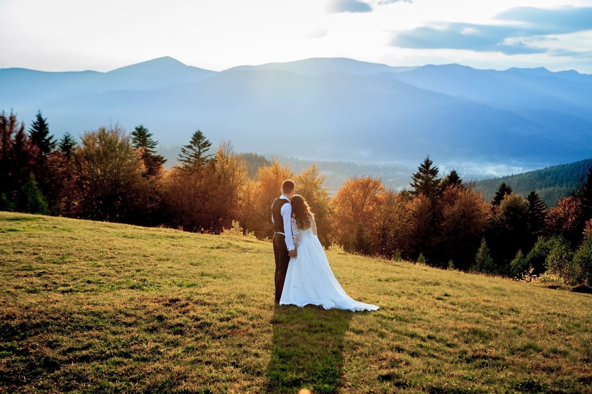 Beautiful wedding couple bride and groom walking together with mountains in background at Moshi Kilimanjaro
