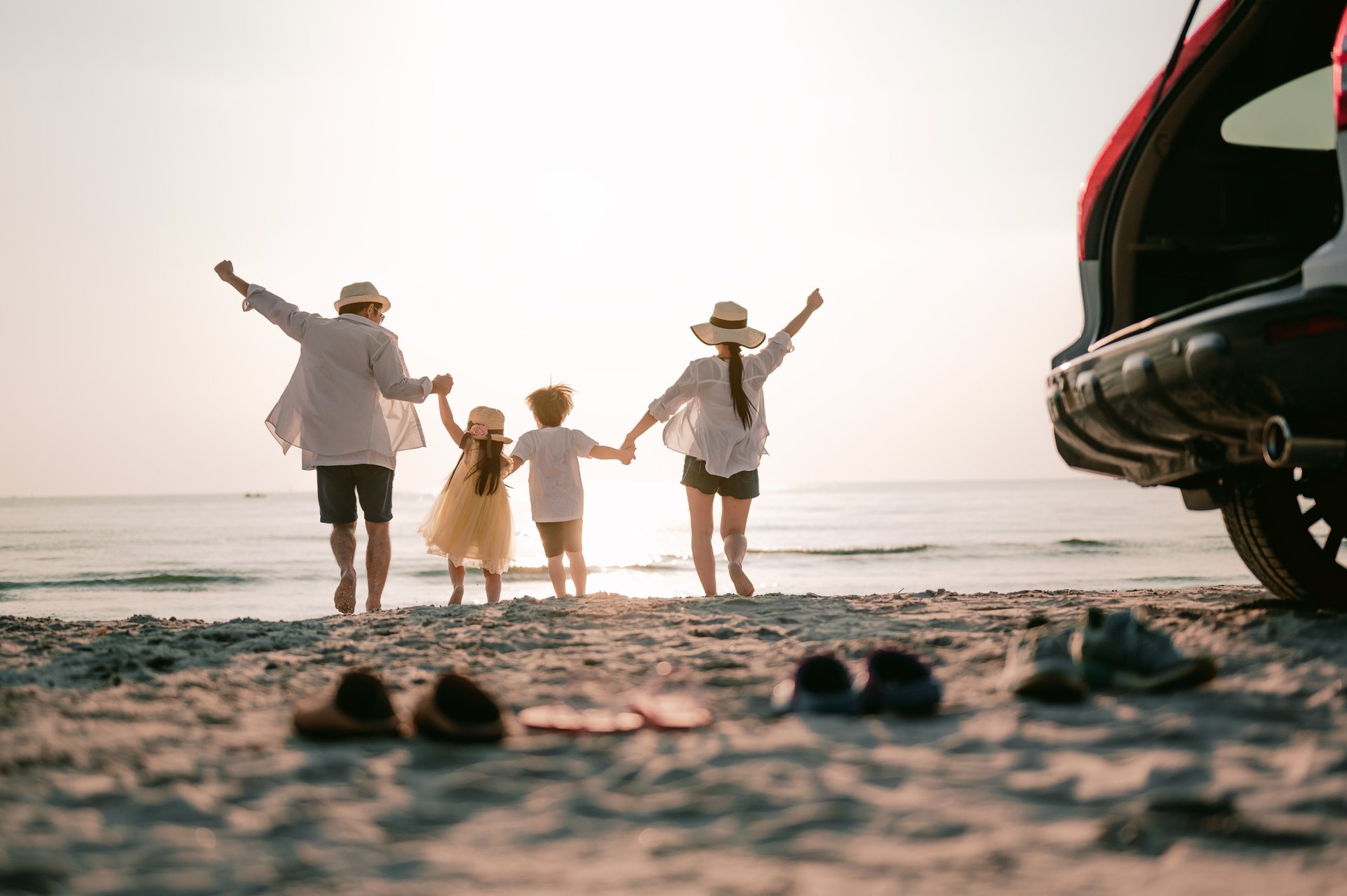 A happy family running together on a tropical beach at sunset during a vacation