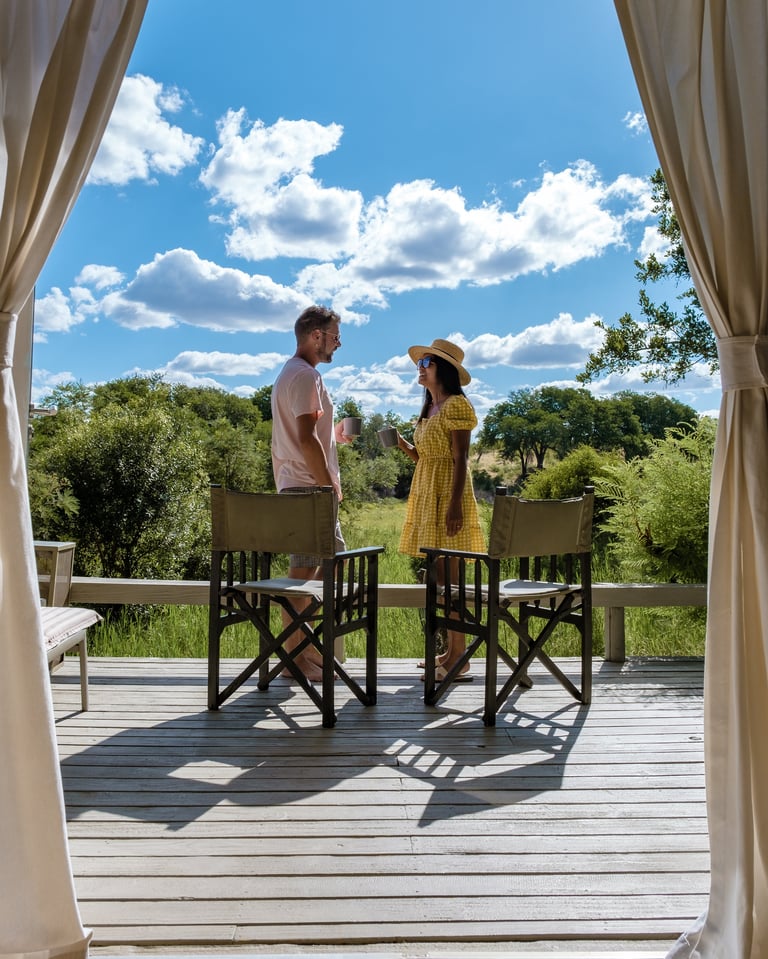 Couple standing in front of a luxury safari tent at a private game reserve