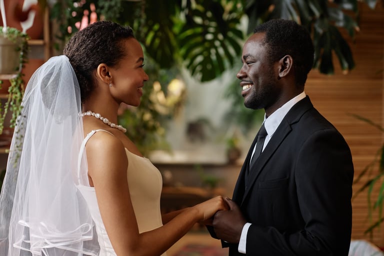 Waist up portrait of young African couple getting married, looking at each other holding hands at Kigoma Lake Tanganyika wedding