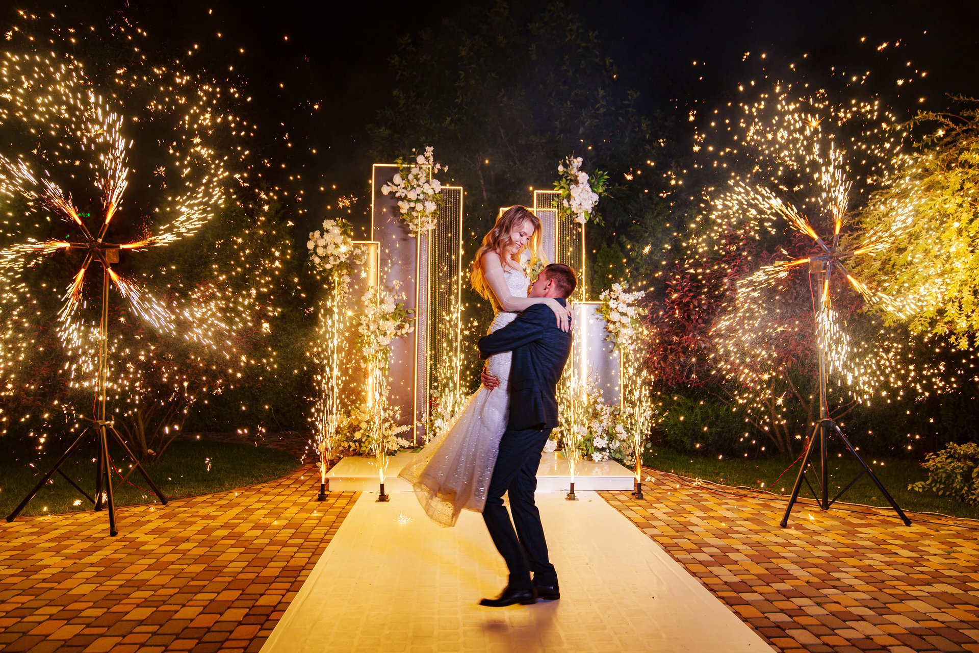 Bride and groom at a professionally planned Tanzanian wedding venue lit at night with fireworks