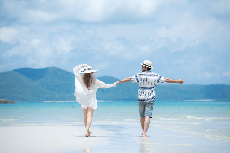 Young couple on a white sandy beach in Zanzibar with clear sky and sea