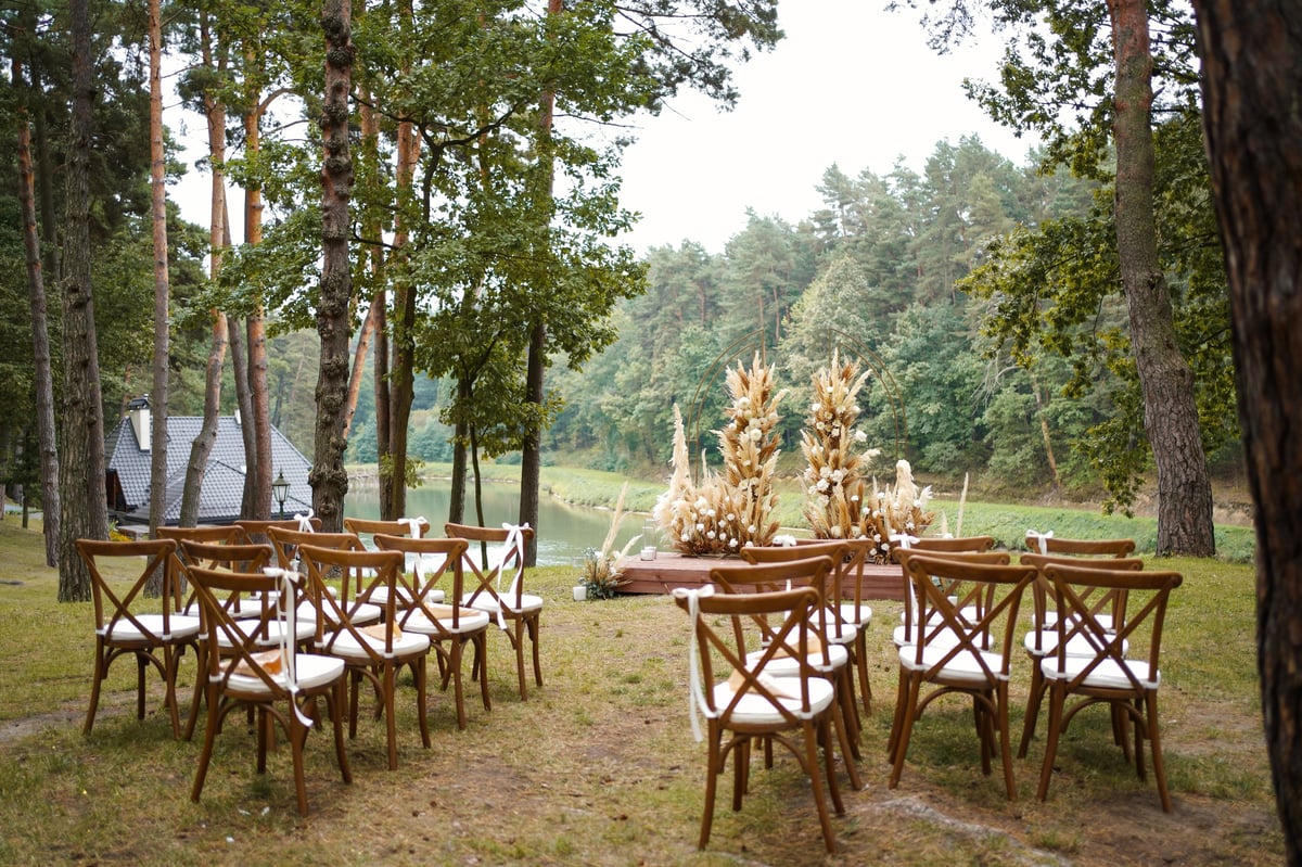 Outdoor wedding arch with flowers and dried grasses at Kilemakyaro Mountain Lodge Moshi with forest ceremony setting
