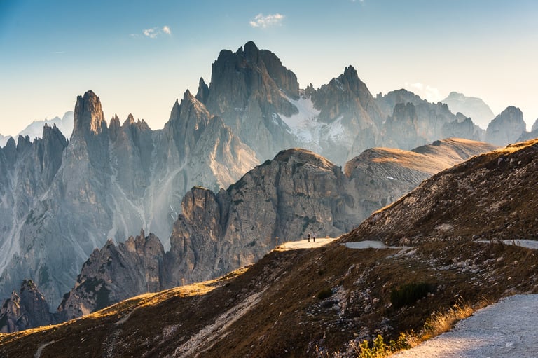 Hiker walking on a scenic rugged mountain pass in alpine landscape
