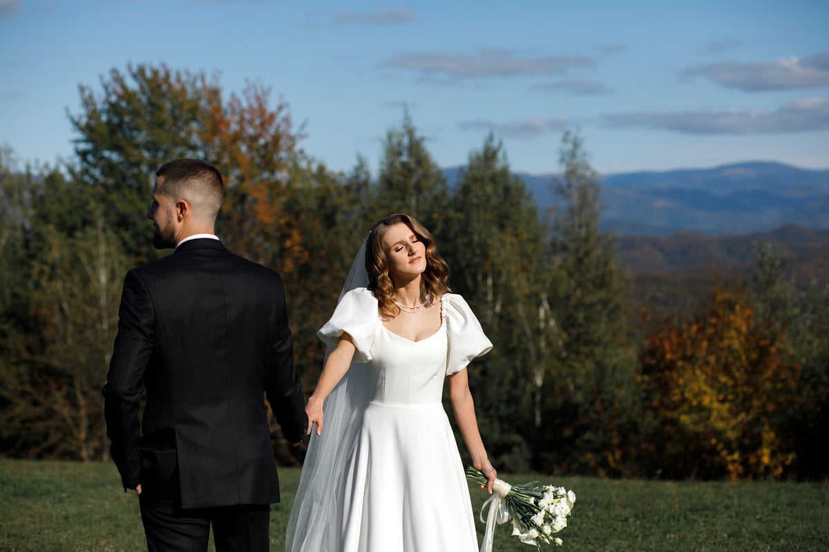 Bride holding bouquet in mountains with Kilimanjaro backdrop at Moshi wedding