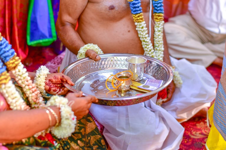 Bride and groom hold a ceremonial tray containing sacred wedding items during a traditional South Indian marriage ceremony