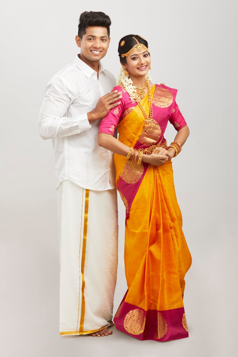 Attractive happy south Indian couple in traditional dress on white