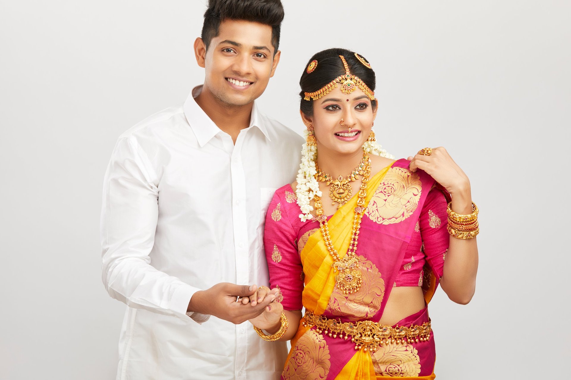 Attractive happy south Indian couple in traditional dress, Studio shot