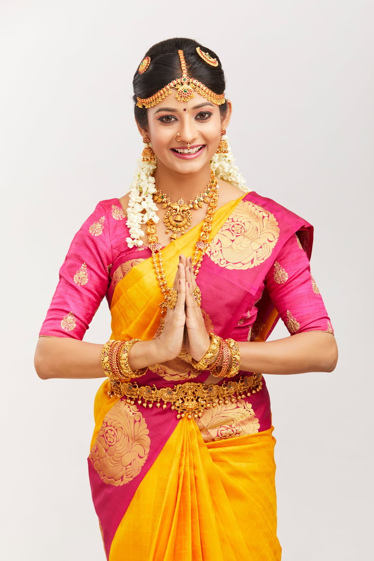 Attractive smiling Indian bride with jewelry in namaste position