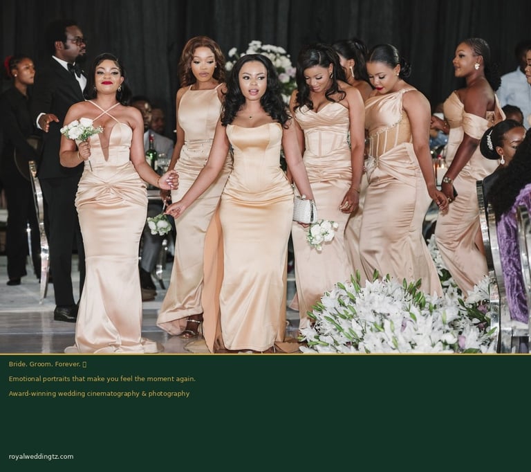 Bridesmaids in coordinated champagne satin gowns standing together at an elegant wedding ceremony with white floral arrangements