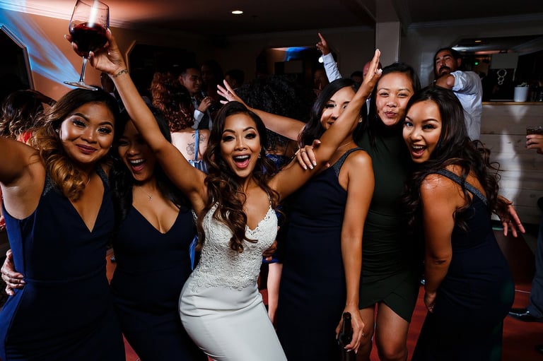 Group of women dancing and celebrating at a nightclub or party venue with colorful lighting