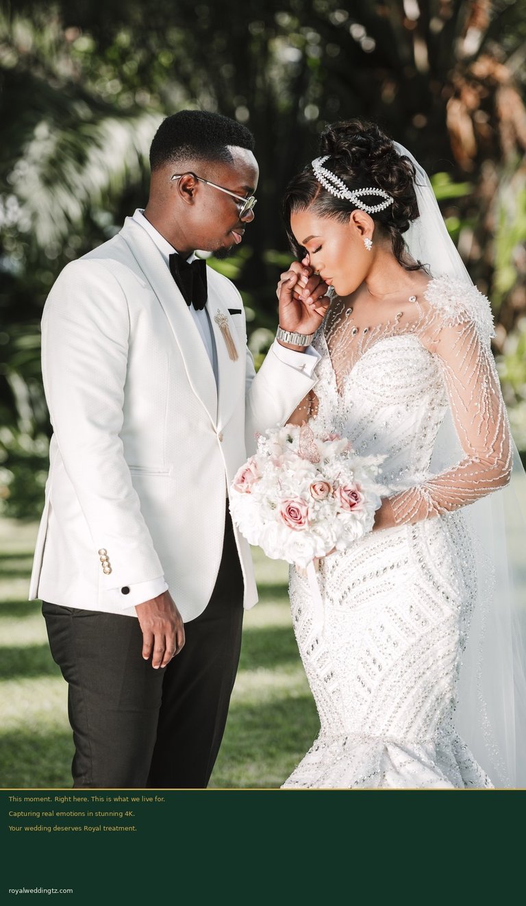 Bride and groom in elegant wedding attire smiling together outdoors, bride holding white bouquet with veil and tiara