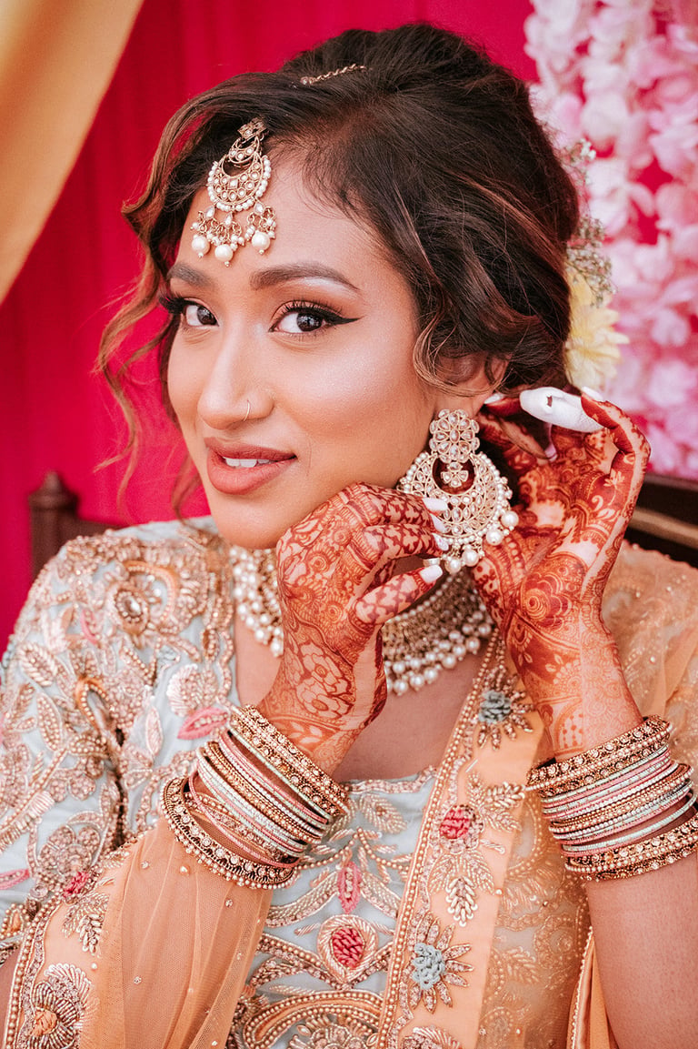 Indian Nikah wedding film Tanzania — South Asian Muslim bride in traditional bridal attire with intricate henna, gold jewelry, and embellished peach wedding dress, cinematic wedding videography