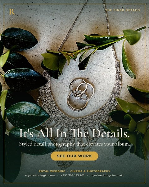 Wedding rings on a textured pendant necklace surrounded by green foliage on a light surface, advertising photography services