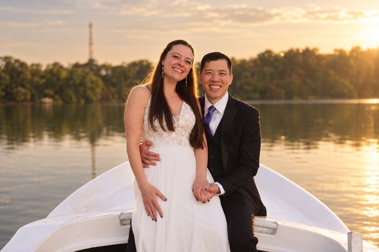 Couple in wedding attire standing on a boat at sunset with the Eiffel Tower visible in the background