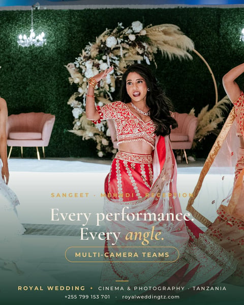 Woman in red traditional Indian wedding lehenga posing under ornate floral arch at luxury wedding venue